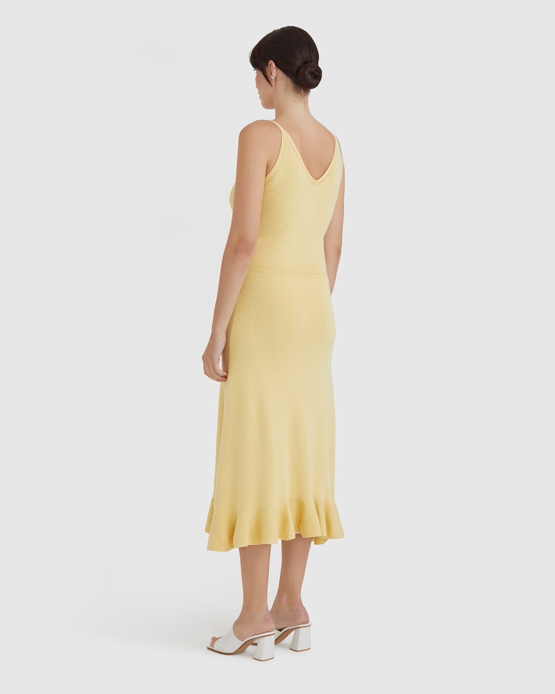 Elegant maize-colored wool dress with fluted hem design.