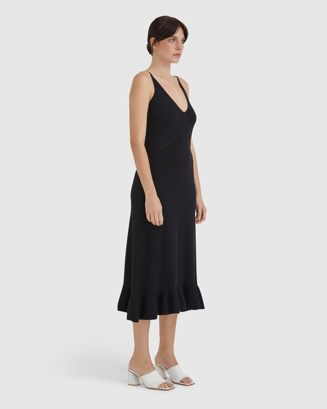 Elegant merino wool knit dress in black with frill hem details.