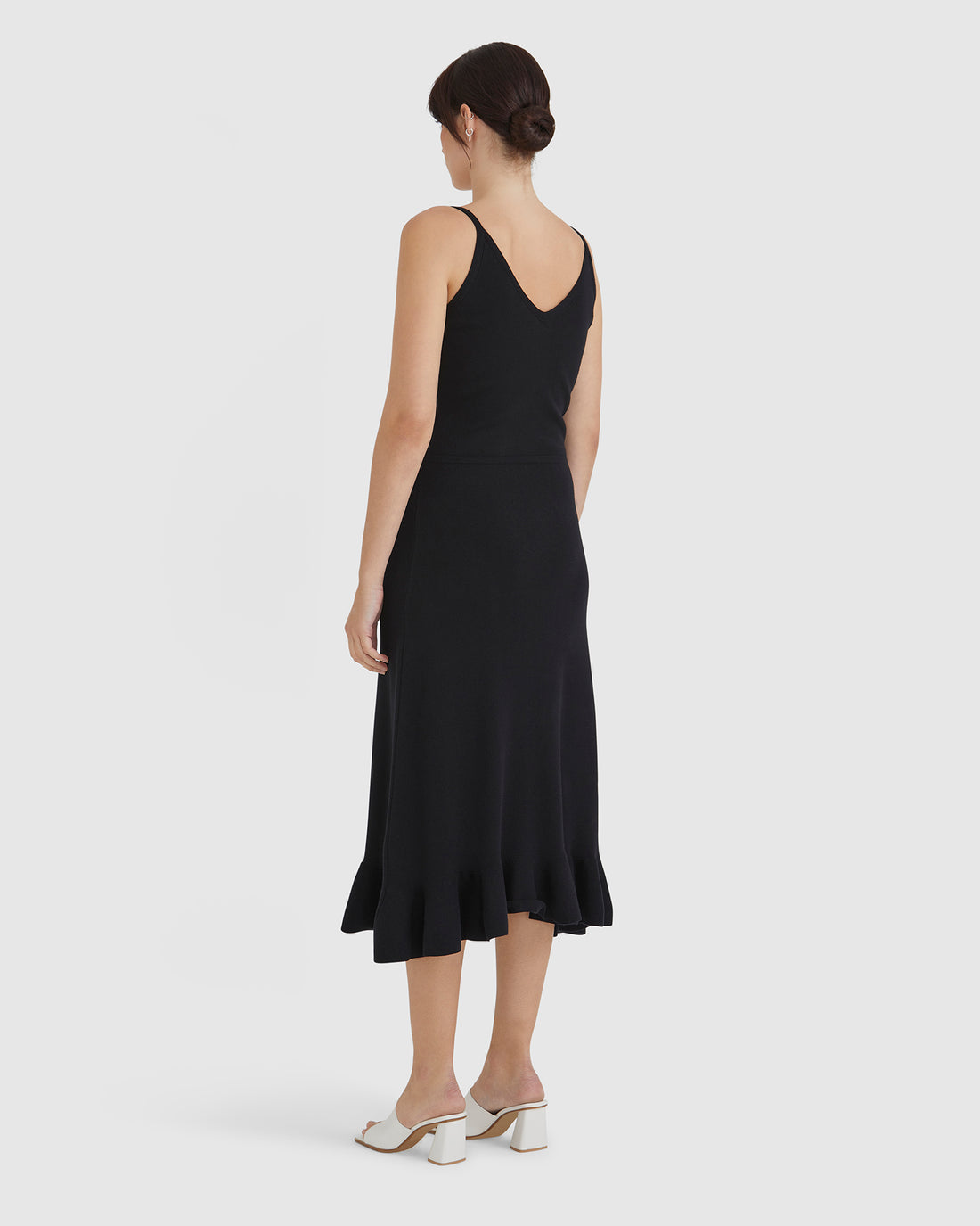 Classic black wool dress with fluted hem, perfect for evening wear.