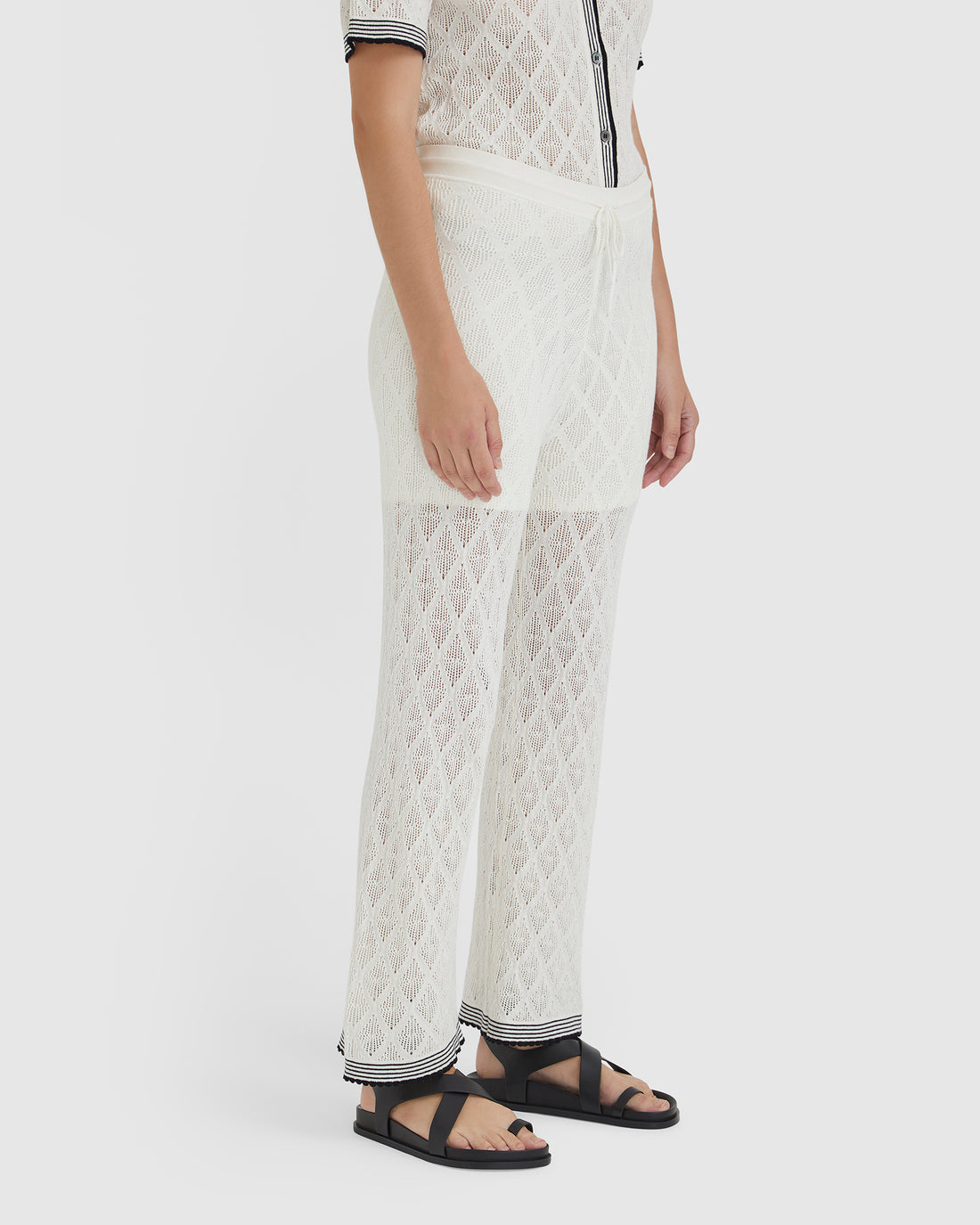 Elegant white lace pants with scalloped trims, ideal for versatile summer styling.