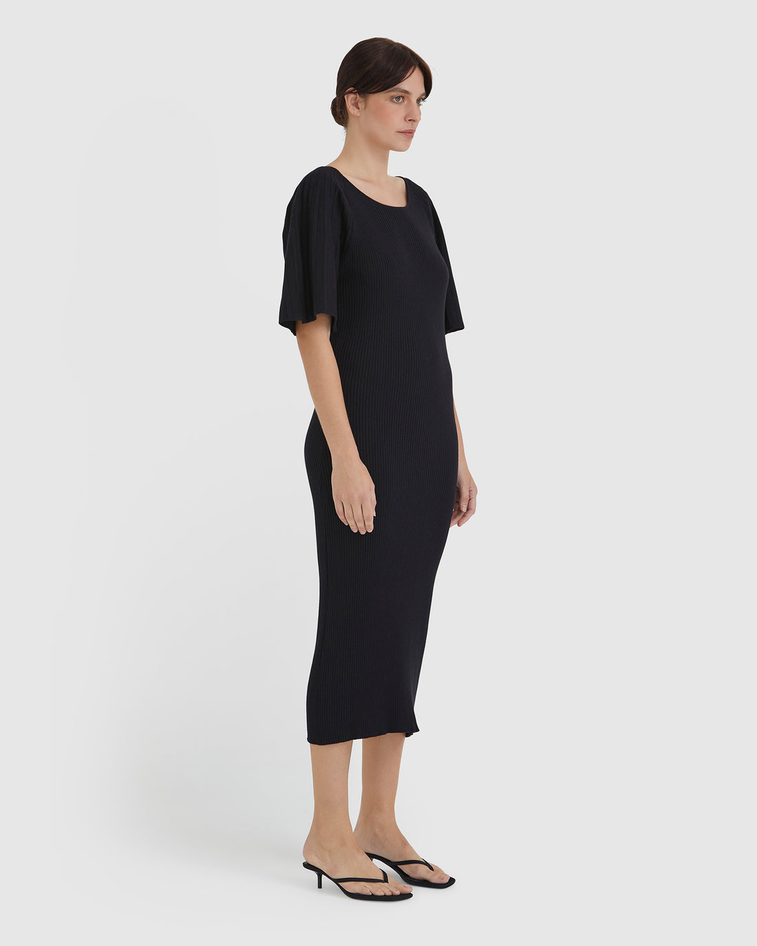 Timeless wool dress with ribbed silhouette and pleated sleeve details.