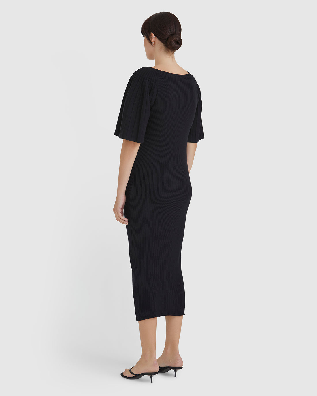 Elegant merino wool knit dress in black with statement pleated sleeves.