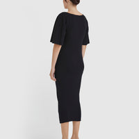 Elegant merino wool knit dress in black with statement pleated sleeves.