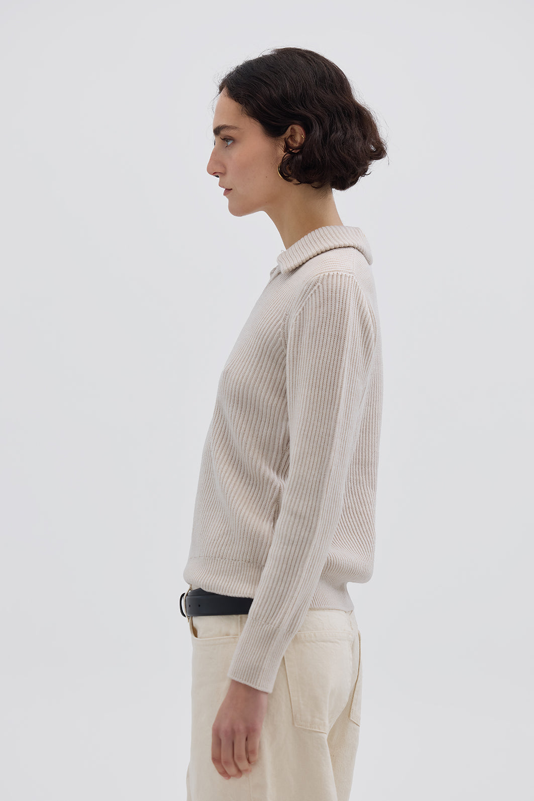 Side view of model in Oat Melange Collar V-Neck Merino Sweater – warm and sophisticated knitwear