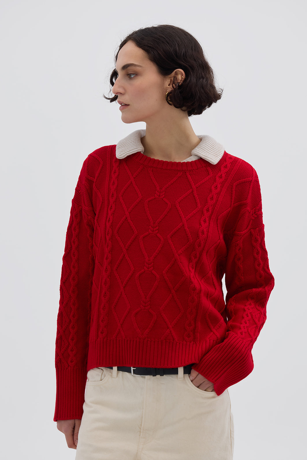 Model wearing the Red Cable Heart Merino Sweater – stylish ladies wool sweater with a bold hue