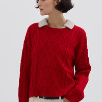 Model wearing the Red Cable Heart Merino Sweater – stylish ladies wool sweater with a bold hue