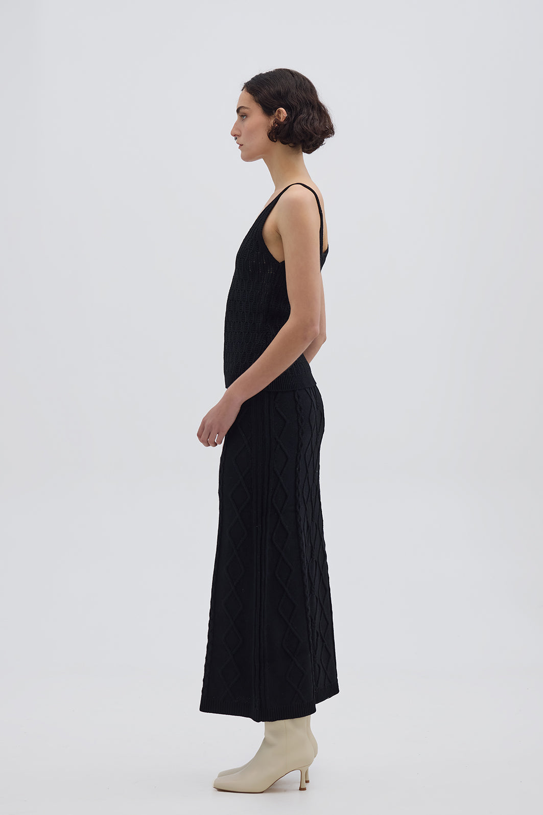 Side profile of model in Black Merino Wool Skirt – sleek silhouette with soft texture