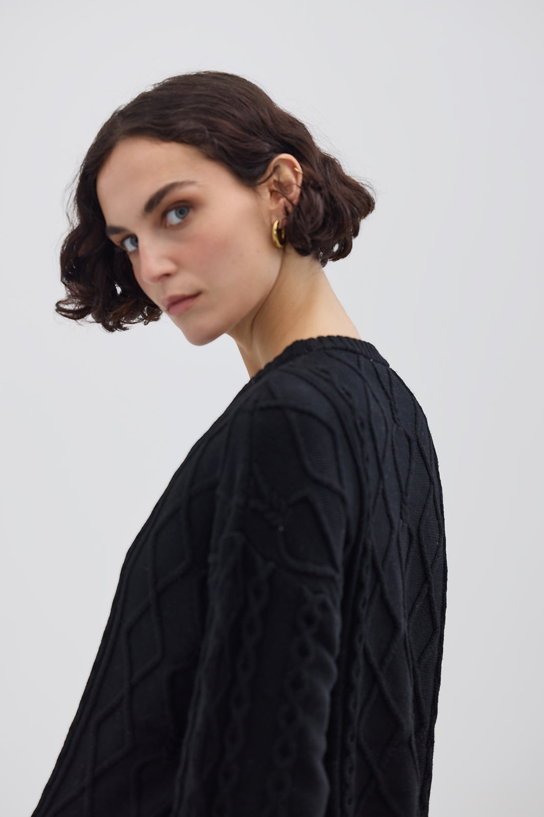 Side profile of model in Black Cable Knit Sweater – warm and effortlessly chic knitwear