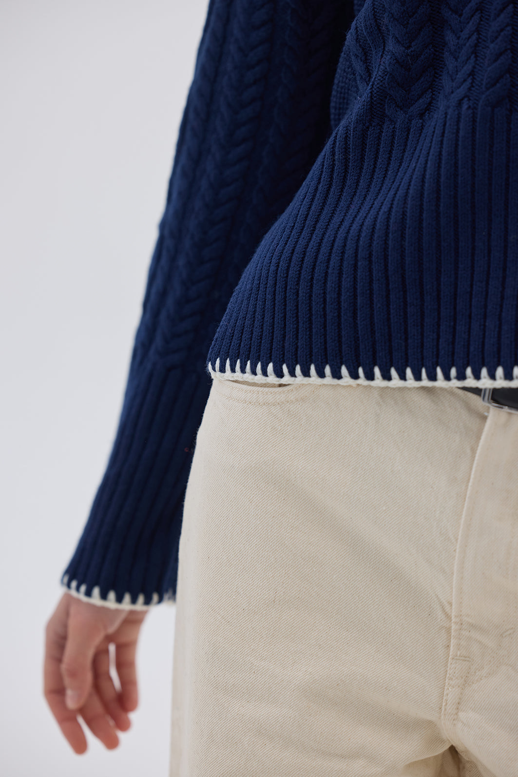 close up of the navy sweater whip stitch detailing.