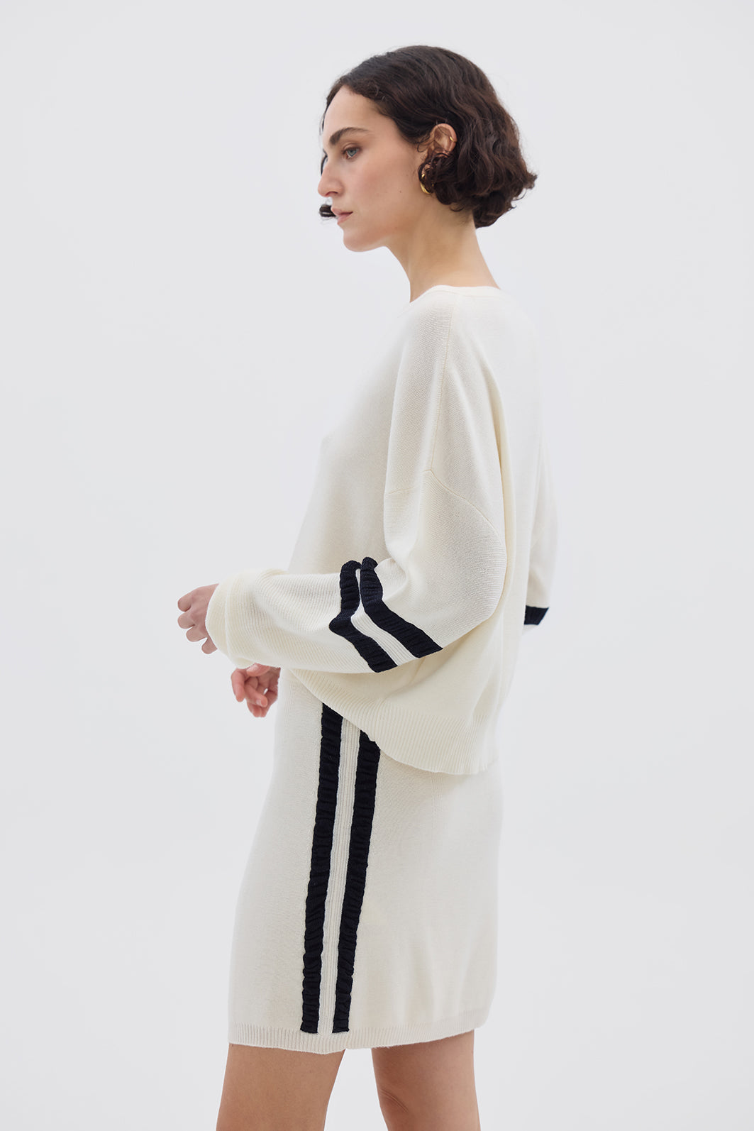 Side profile of model in Cream Striped Wool Sweater – modern, warm, and lightweight knitwear