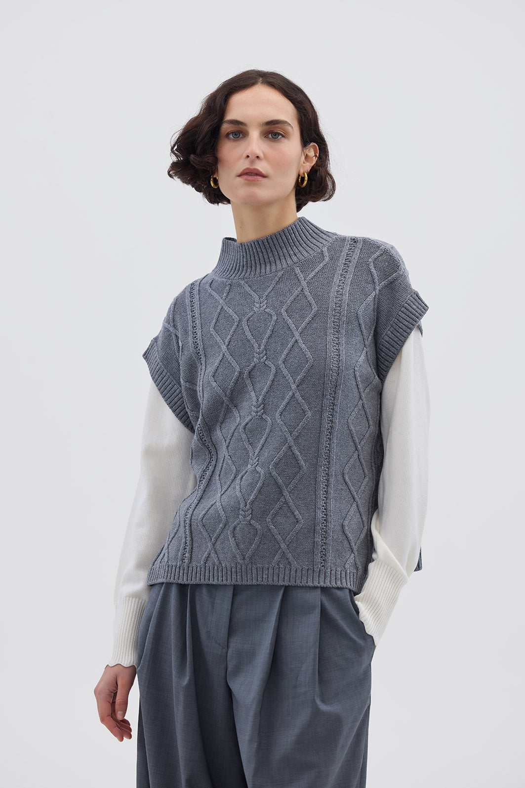 Model wearing Knitted Vest Grey – elegant sleeveless ladies wool vest with heart cable-knit detail