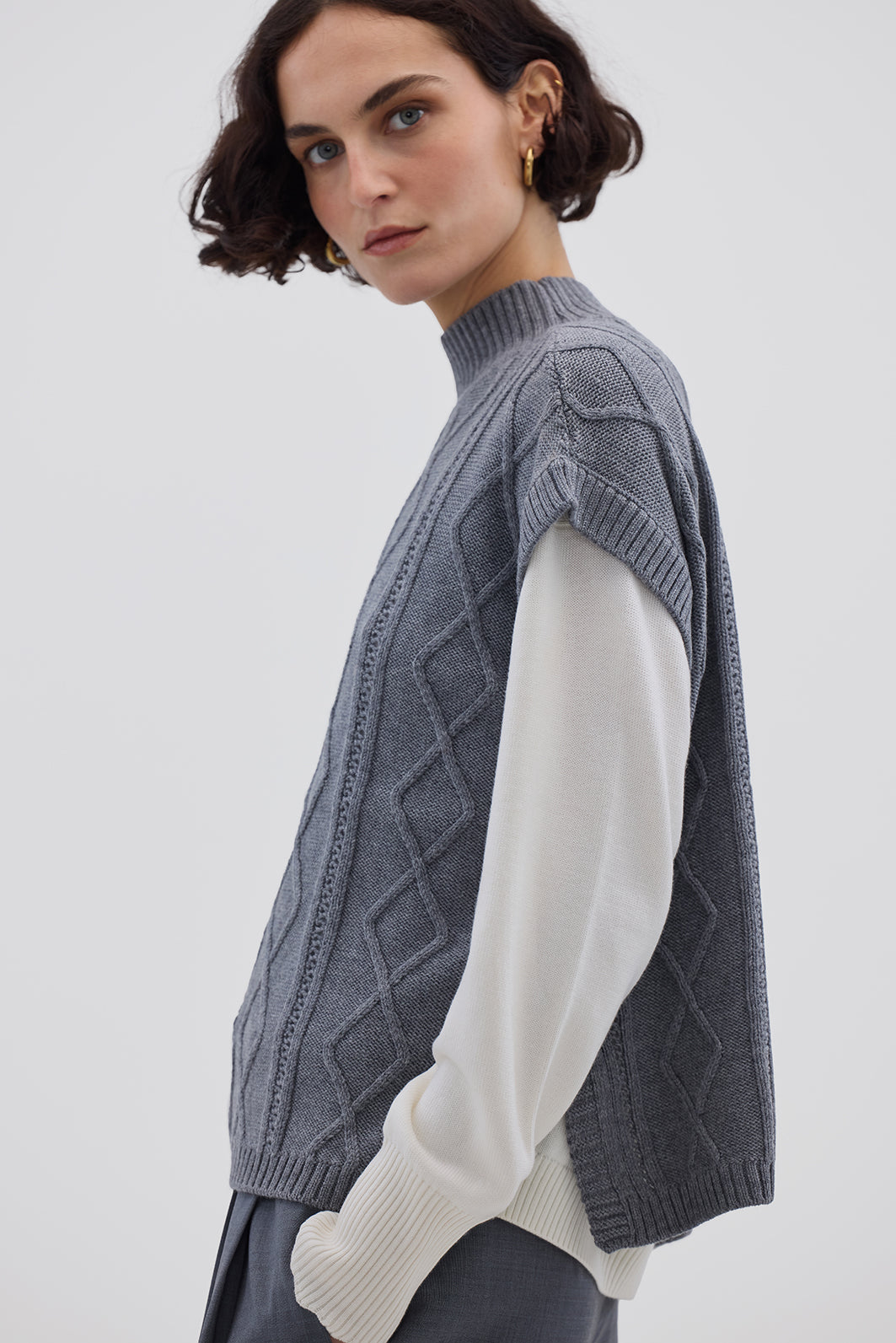 Side view of model in Grey Knitted Vest – lightweight, warm Merino wool layering piece