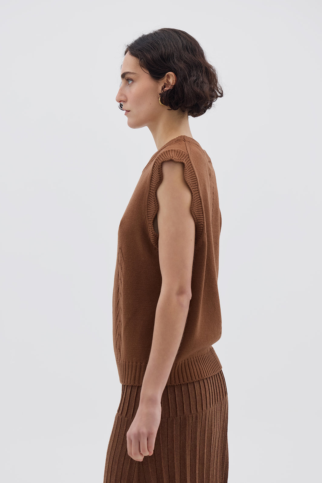 Side profile of model in Walnut Wool Vest – classic sleeveless design with a timeless crew neckline