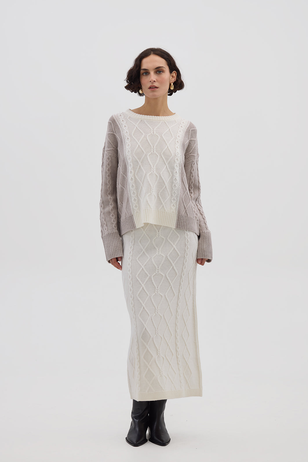 A Beautiful Merino Wool Sweater in Oat Melange, made from 100% pure Merino wool with a cable-knit pattern and relaxed fit. Shop now!
