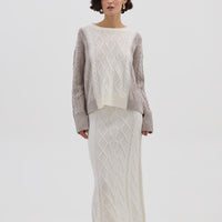 A Beautiful Merino Wool Sweater in Oat Melange, made from 100% pure Merino wool with a cable-knit pattern and relaxed fit. Shop now!