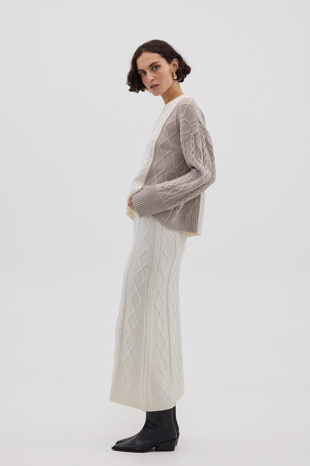 Side profile of model in Oat Melange Cable Knit Sweater – warm and effortlessly elegant knitwear