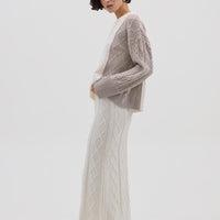 Side profile of model in Oat Melange Cable Knit Sweater – warm and effortlessly elegant knitwear