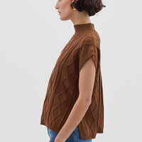 Side view of model in Brown Cable Vest – timeless and cozy Merino wool layering piece