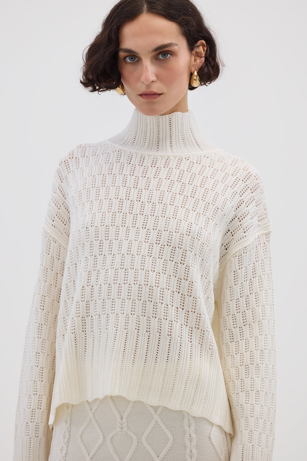 Model wearing the Cream Corded Rib High Neck Merino Sweater – soft and breathable ladies wool sweater