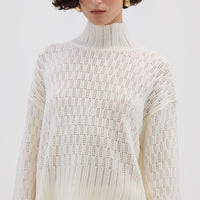 Model wearing the Cream Corded Rib High Neck Merino Sweater – soft and breathable ladies wool sweater