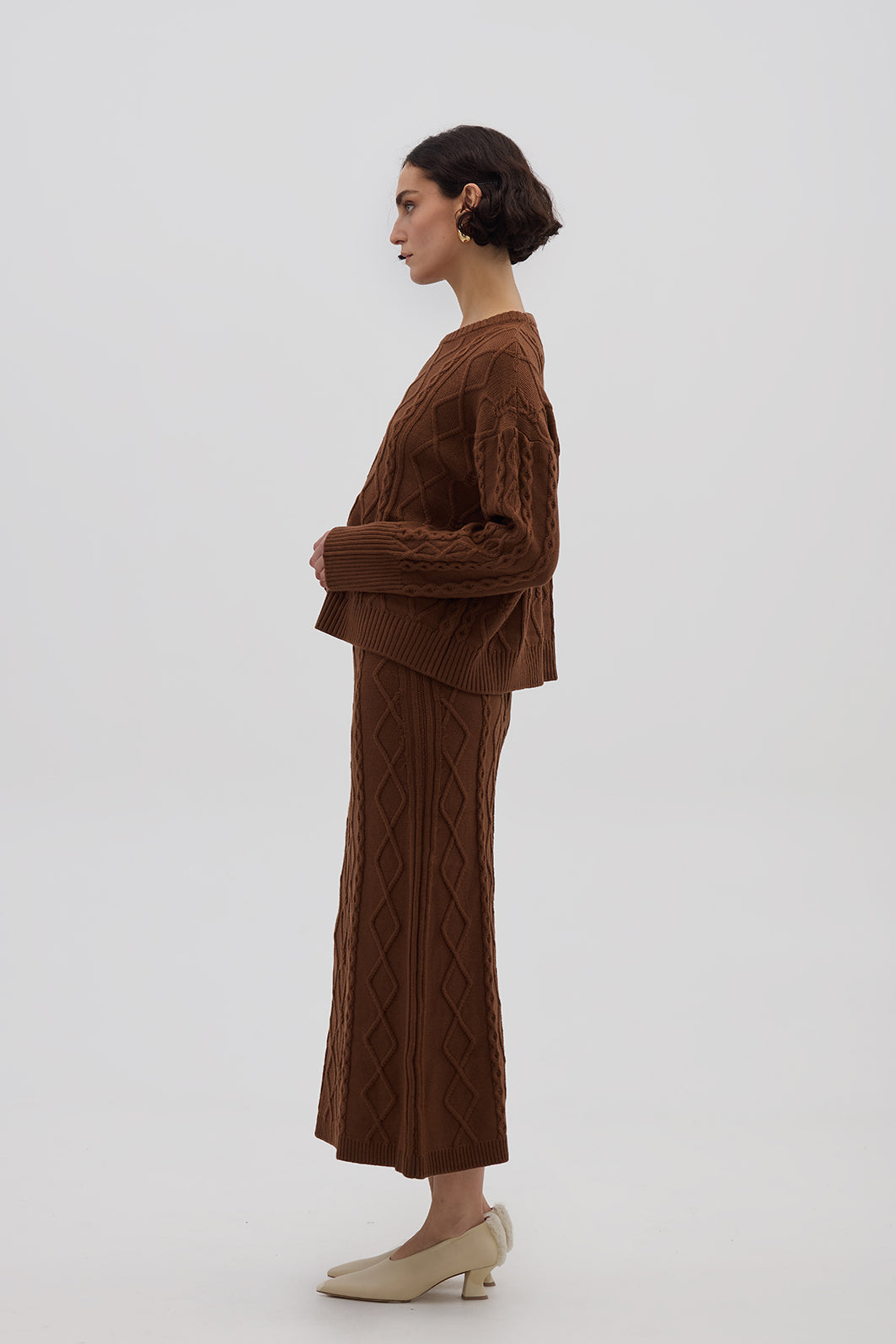 Side profile of model in Brown Merino Wool Skirt – flowing maxi-length silhouette with elegant texture