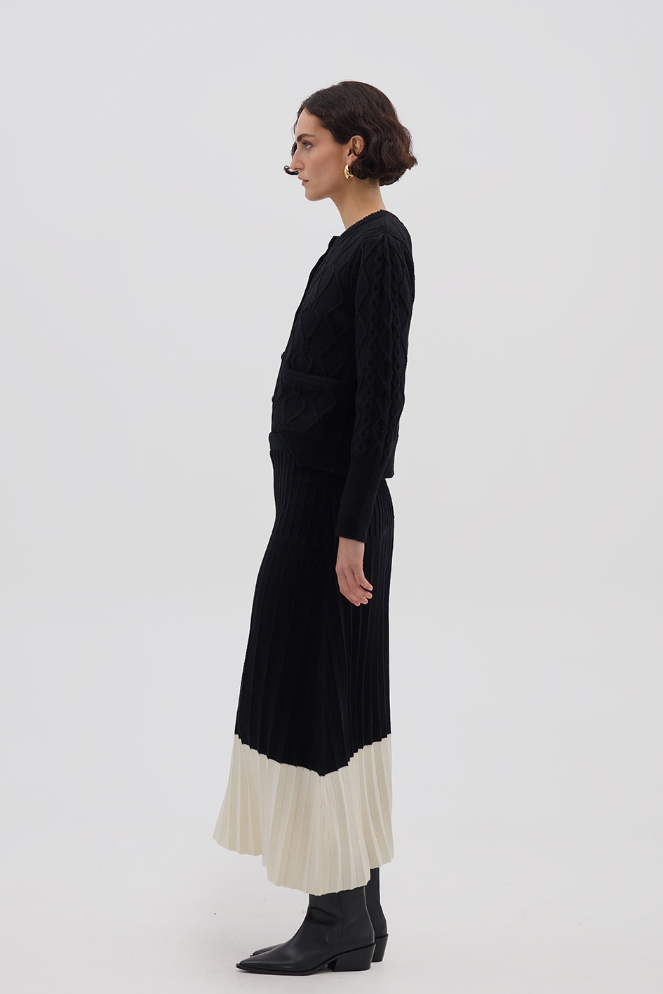 Side profile of model in Black Wool Skirt – flowing silhouette with modern contrast detailing