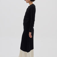 Side profile of model in Black Wool Skirt – flowing silhouette with modern contrast detailing