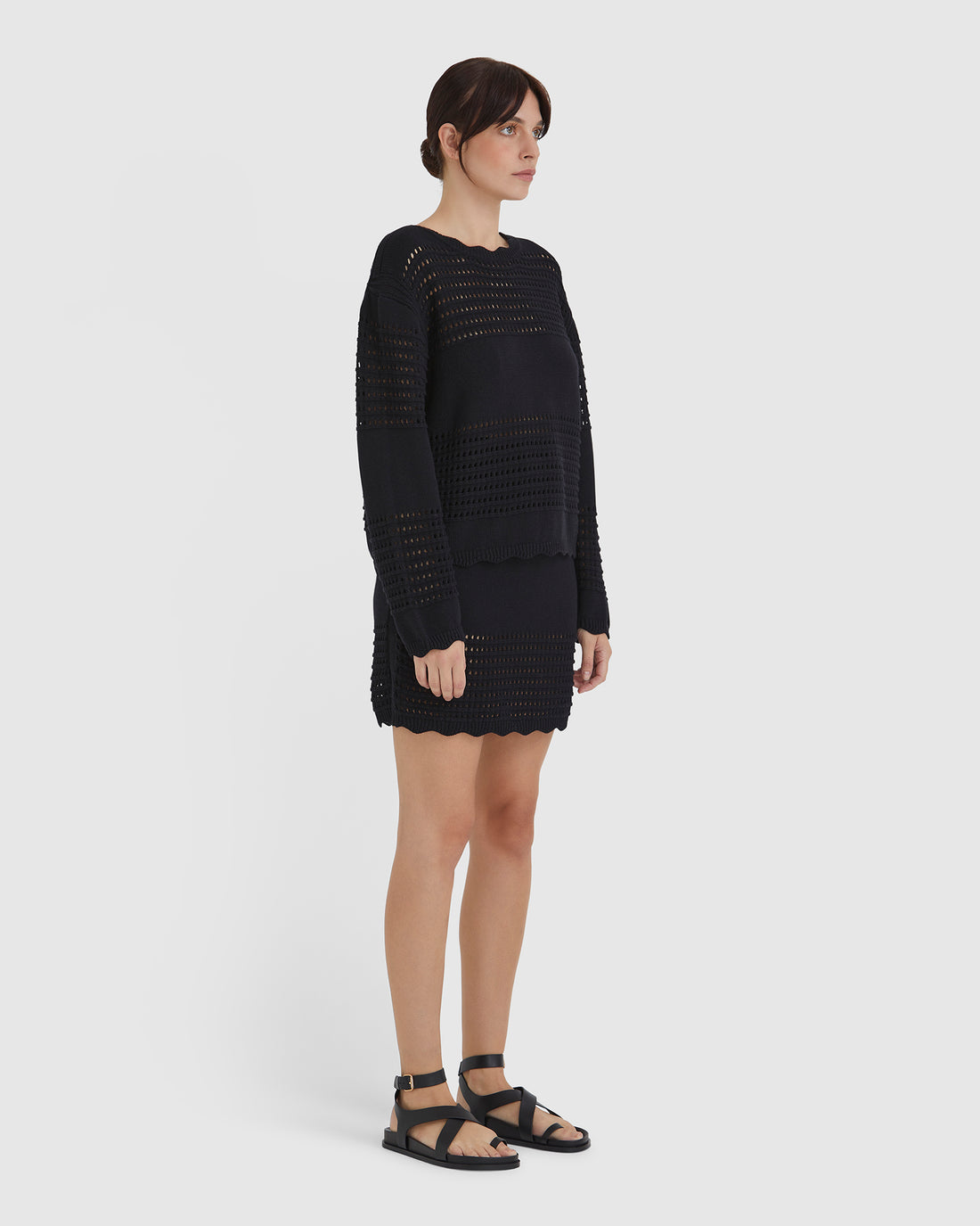 Classic black wool sweater with crochet texture for summer layering.