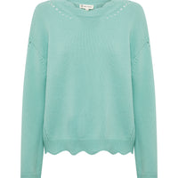 The image shows a sage wool sweater featuring a soft, smooth knit texture.