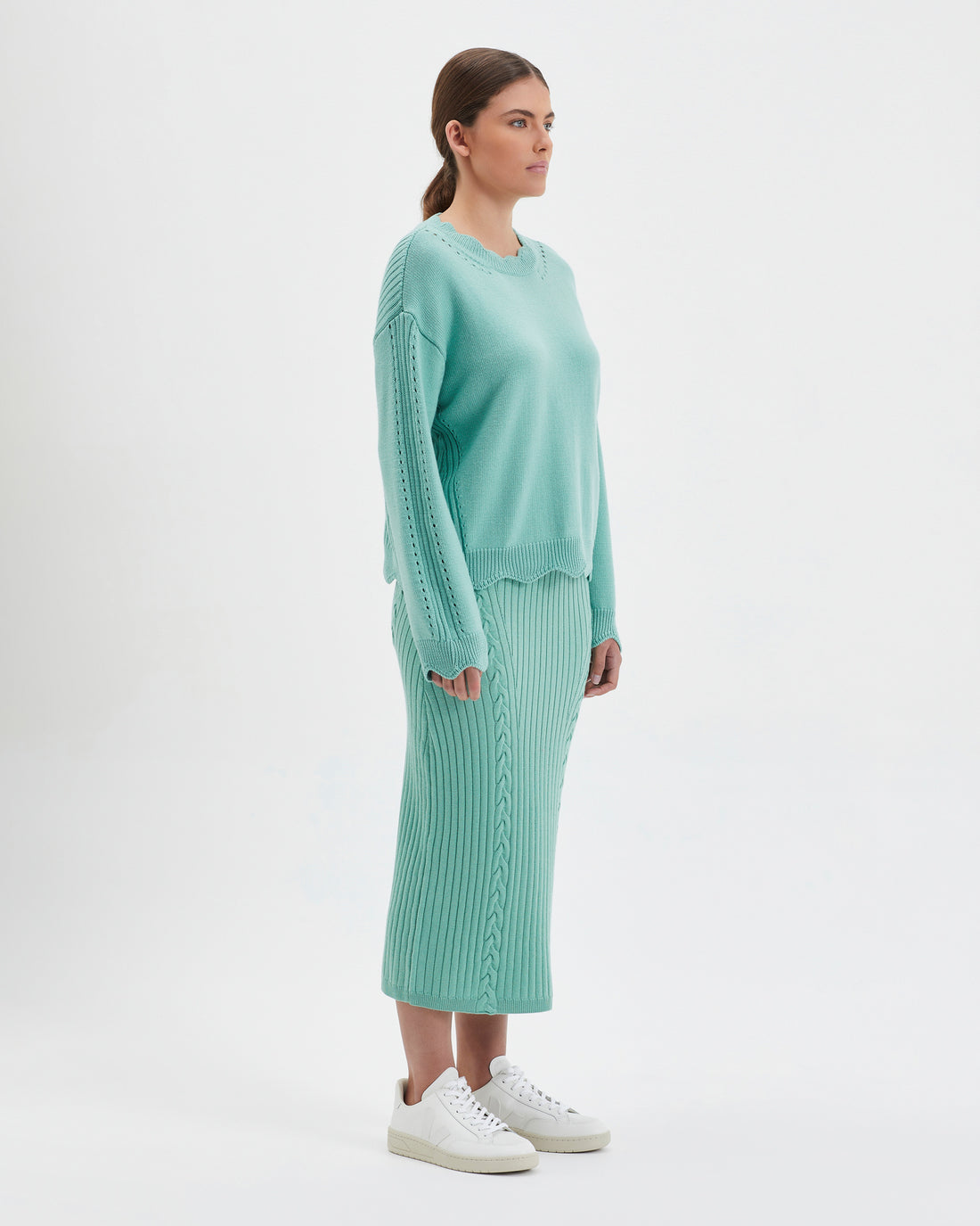 Elegant sage womens knit sweater with scalloped edges and cozy wool texture.