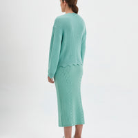 Feminine wool sweater in sage featuring delicate scalloped details on neckline, waist, and cuffs.