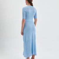 The dress features a fitted bodice with short sleeves, intricate pointelle details.