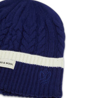 Navy merino wool beanie with elegant plaited design for women.