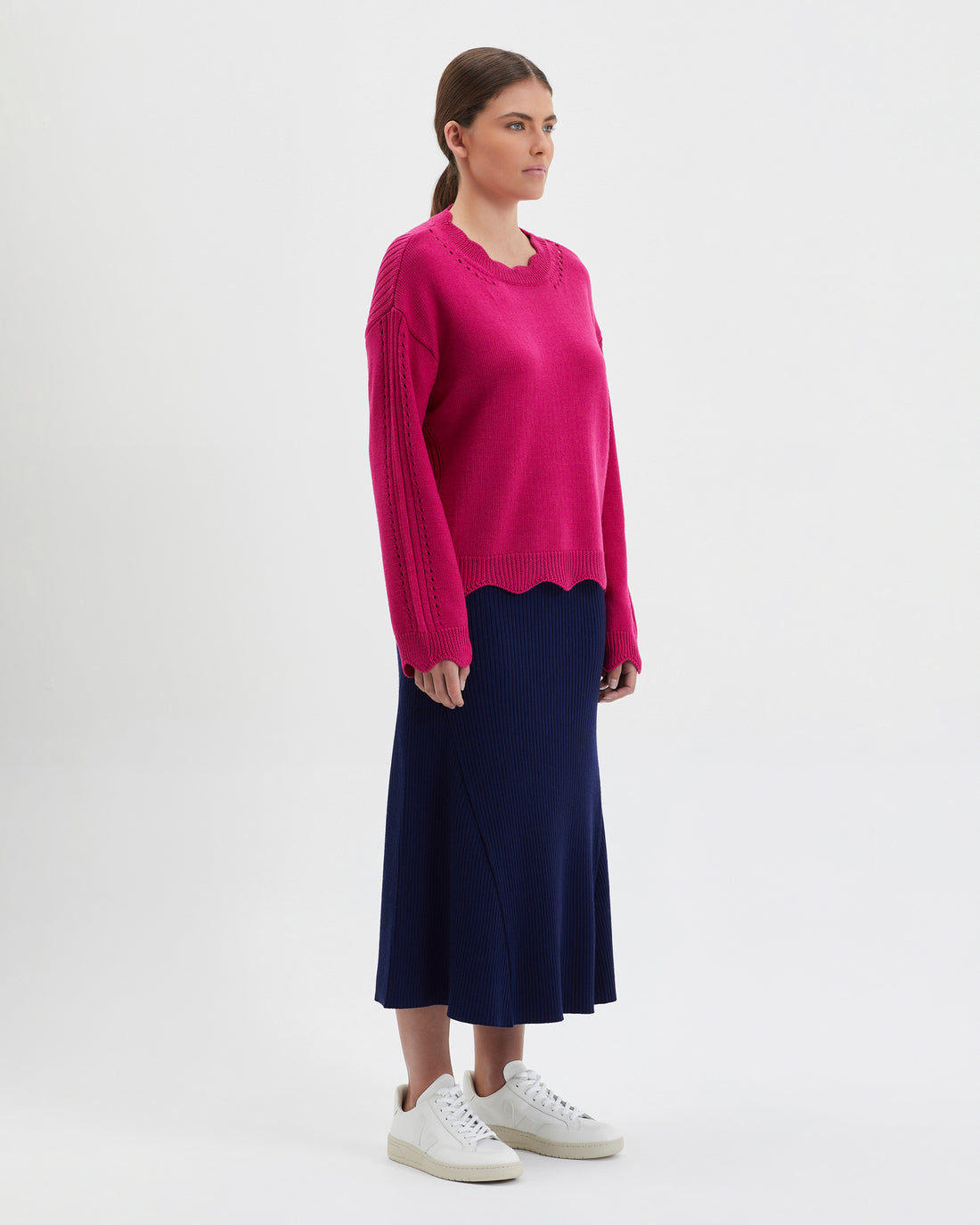 Feminine wool sweater with scallop details on neckline, waist, and cuffs.