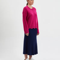 Feminine wool sweater with scallop details on neckline, waist, and cuffs.