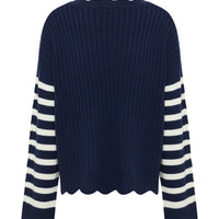 The back view of a classic navy and white ribbed sweater with scalloped hem detailing.