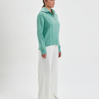 Half-zip wool sweater in sage Merino wool, perfect for casual winter layering.