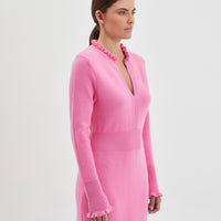 The dress showcases a flattering deep V-neckline framed by a delicate ruffled trim for a feminine touch