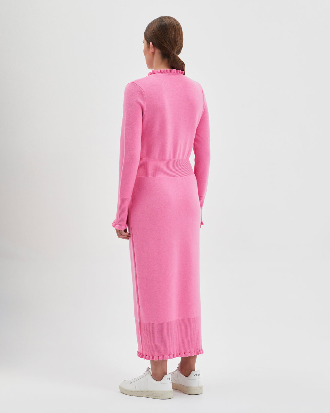 Back view of the candy pink little river merino wool dress with romantic frills.