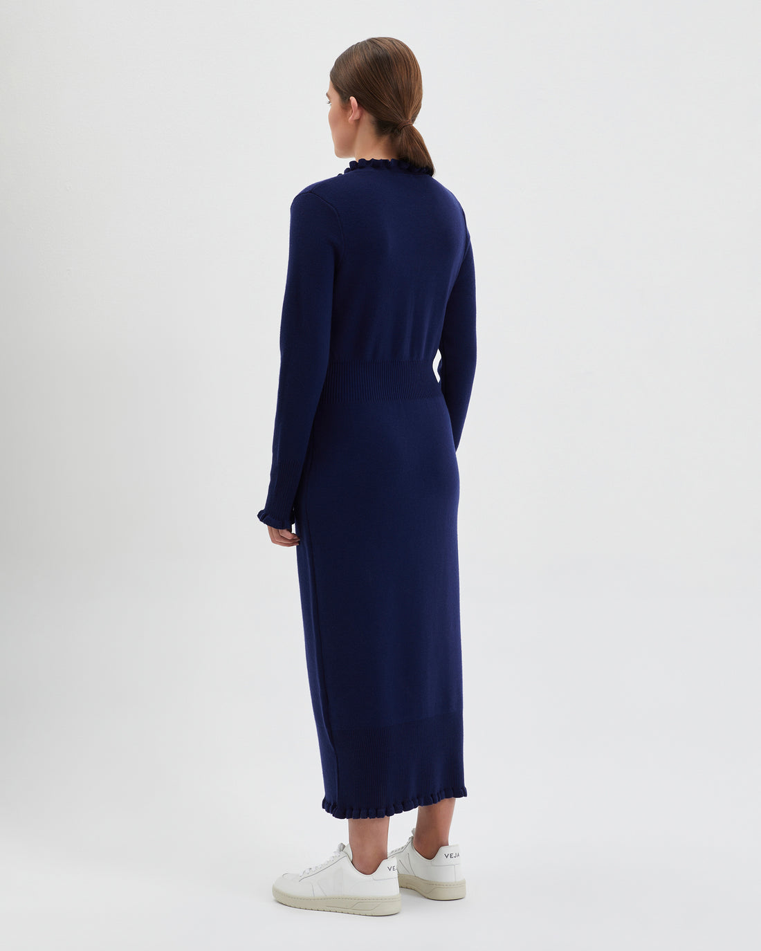 Back view of the navy wool little river dress with romantic frills.