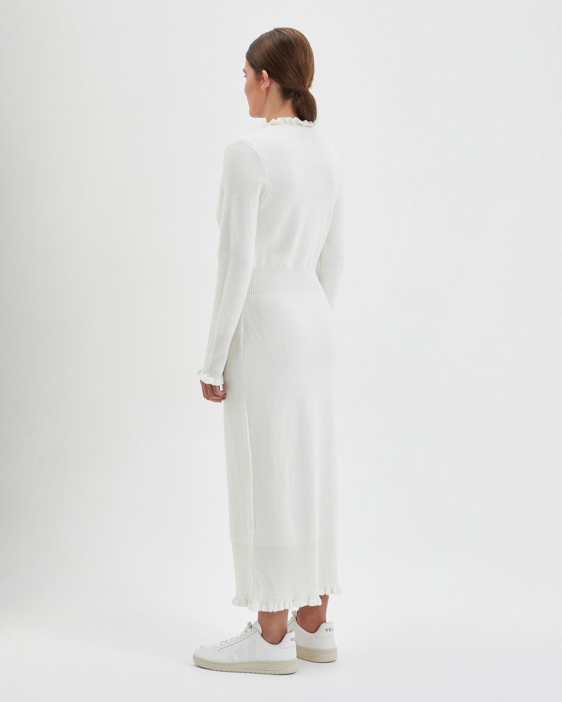 Back view of the ivory little river wool dress with romantic frills.