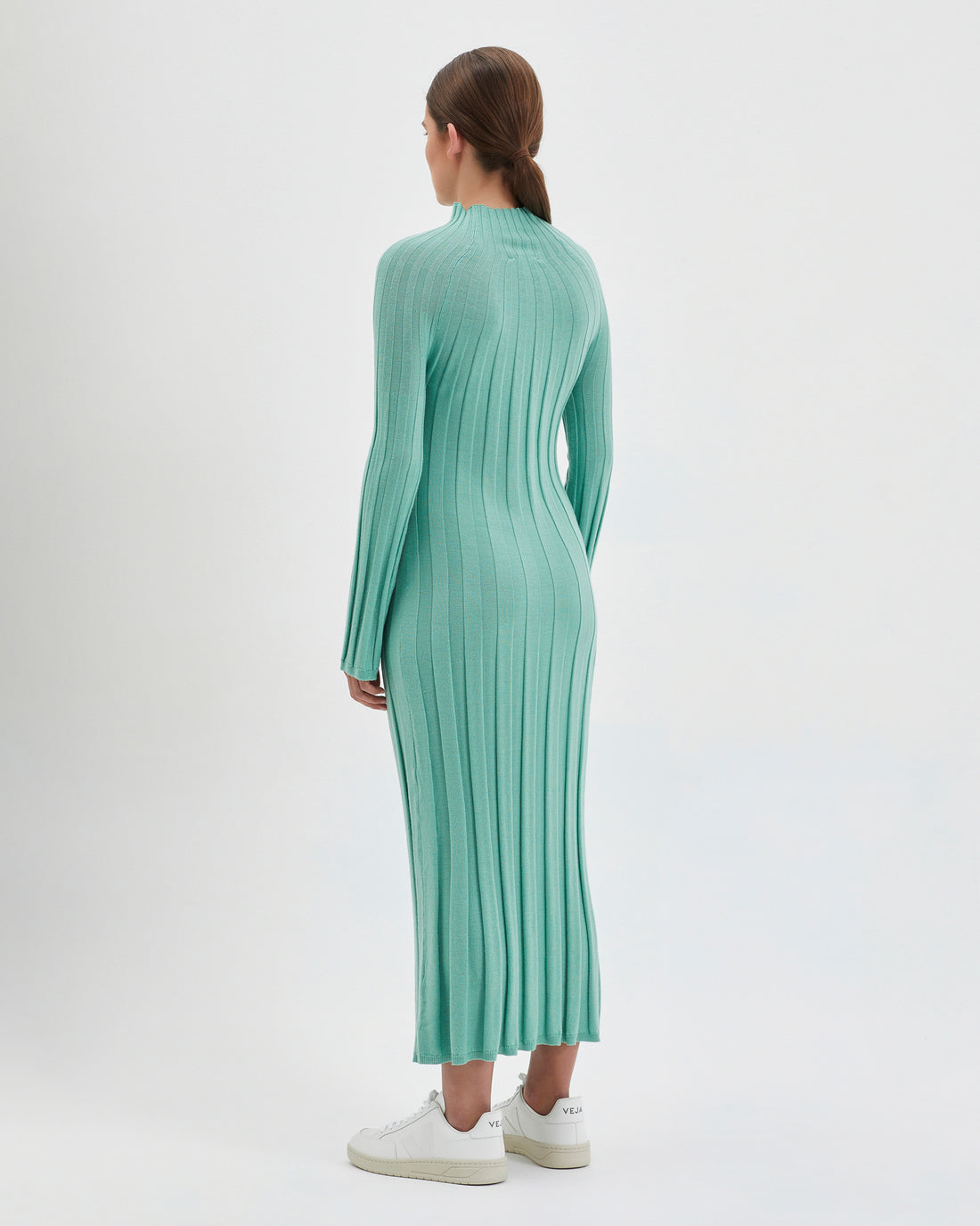 The wool dress is designed with a ribbed knit pattern that elegantly contours the figure.
