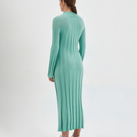 The wool dress is designed with a ribbed knit pattern that elegantly contours the figure.