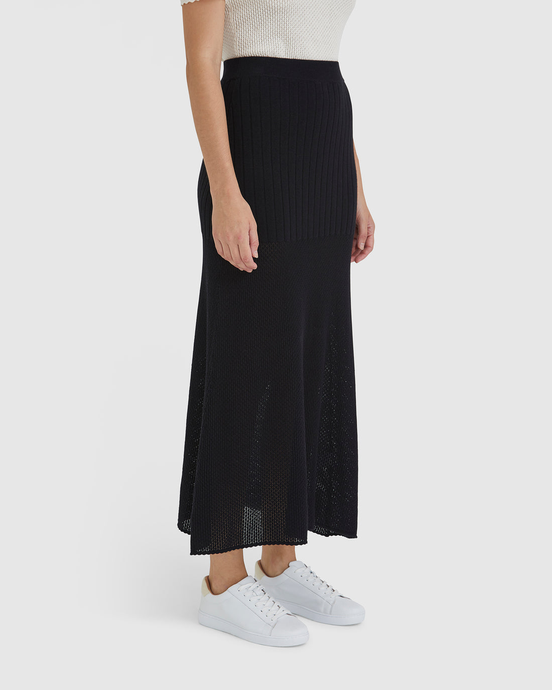 Close-up of black maxi skirt in wool blend with ribbed pointelle details.