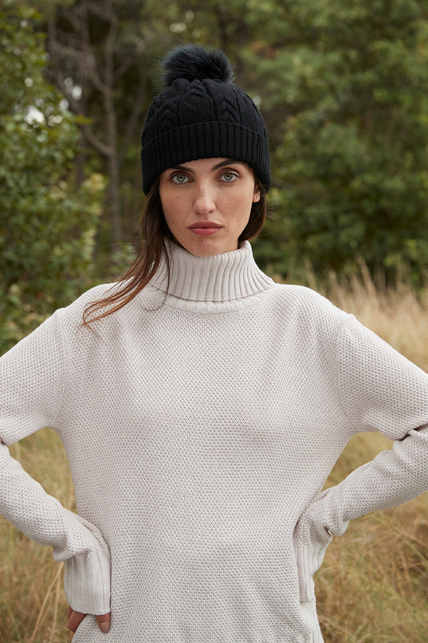 Black merino wool beanie with elegant cable-knit pattern for women.