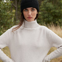 Black merino wool beanie with elegant cable-knit pattern for women.