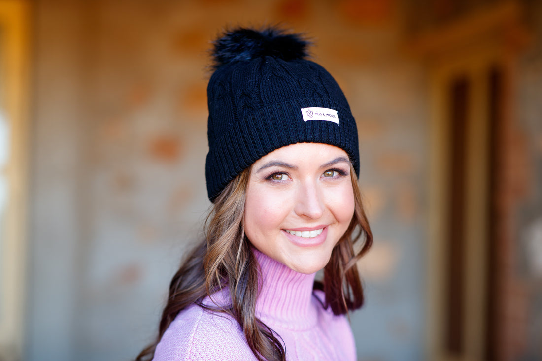 Close-up of black cable-knit wool beanie in high-quality merino wool.