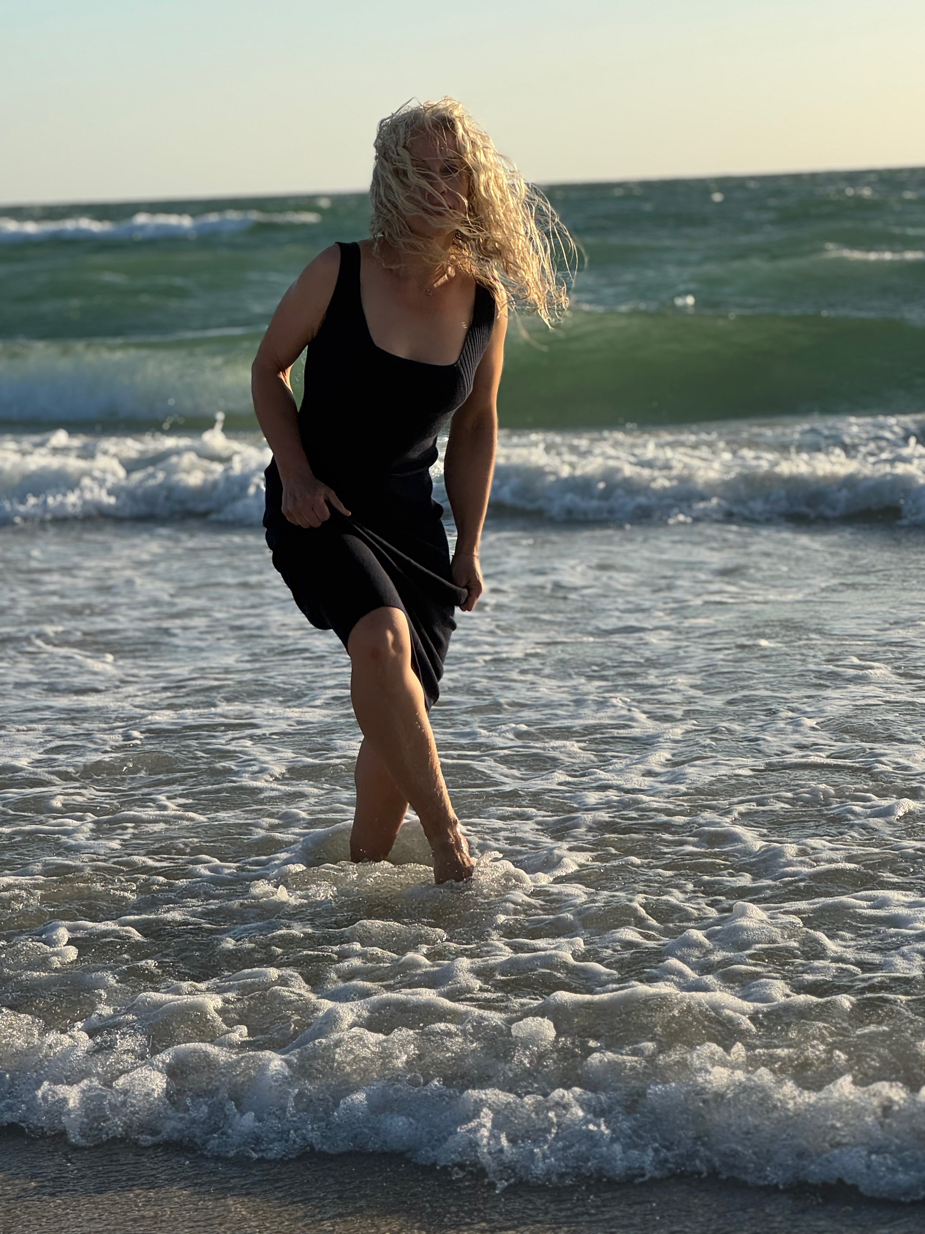 Sustainable fashion in motion - Liz Cook stuns in a chic knit sweater and skirt set by the shore.