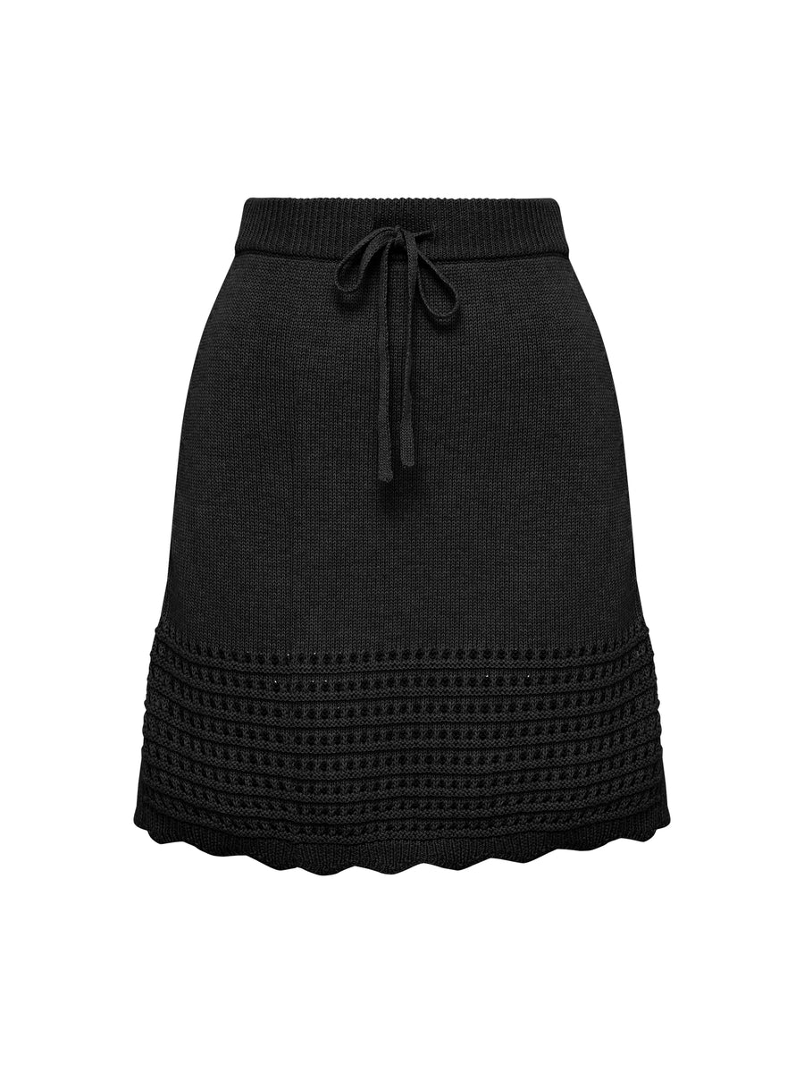 Close up of black mini skirt with crochet and scallop details.