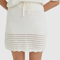 Cream crochet mini skirt with drawstring waist and scalloped hem.